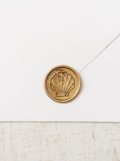 Beautiful gold wax seals featuring a line drawing of a sea shell